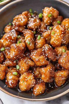 chicken with sesame seeds in a black bowl