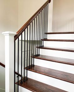 a set of stairs with wooden handrails in a home's entryway