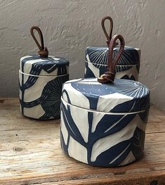 three blue and white containers sitting on top of a wooden table