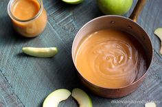 an apple cider with apples and caramel sauce in the bowl next to it