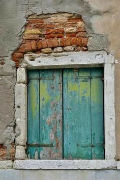 an old building with a green door and brick window sill on the outside wall