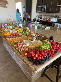 a kitchen counter covered in lots of different types of fruits and veggies on it