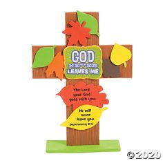 a wooden cross with leaves on it and the words god never leaves me above it