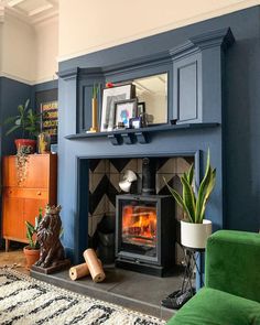 a living room filled with furniture and a fire place next to a green chair on top of a rug