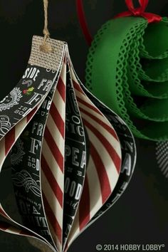 an ornament hanging from a string on a black background with red, white and green ornaments