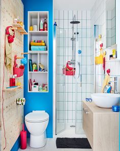 this bathroom has blue walls and white tile on the floor, along with colorful accessories