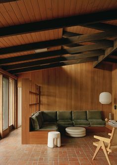 a living room with wood paneling and brick flooring on the walls is shown