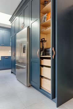 a kitchen with blue cabinets and stainless steel appliances