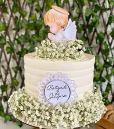 there is a wedding cake decorated with flowers and an angel figurine on top