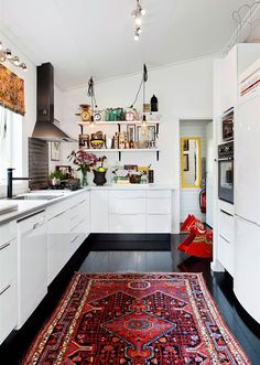 an image of a kitchen with white cabinets and rugs