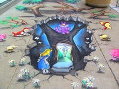 this is an image of a sidewalk with some artwork on the ground and flowers around it