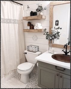 a white toilet sitting next to a bathroom sink under a mirror with shelves above it