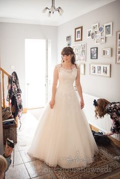 a woman in a wedding dress standing on a rug