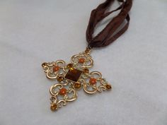 Beautiful gold toned cross with brown stones on a long brown ribbon. Gold Cross Necklace For Party, Adjustable Brown Cross Necklace, Ribbon Cross, Brown Ribbon, Horse Earrings, 25 May, May 2024, Dress Jewelry, Brown Shoe