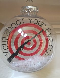 a glass ornament with a target and the words shoot your arrow on it