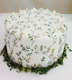 a cake with white frosting and green leaves on it