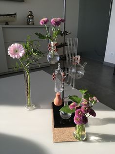 three vases filled with flowers on top of a table