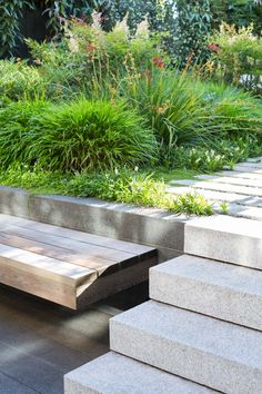 a wooden bench sitting in the middle of a garden