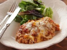 a white plate topped with lasagna and salad