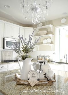 a kitchen counter with white dishes and cups on it