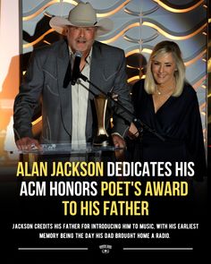 a man and woman standing next to each other in front of a podium with an award