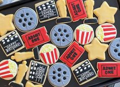 decorated cookies with movie themed decorations on a cookie sheet in the shape of film reels and popcorn