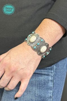 This one-of-a-kind silver bracelet is a real gem! Featuring unique turquoise and white stones, it's sure to add a sparkle to any outfit. So slip it on and show the world your fashionable flair!  width: 1.25  Dont forget to add the matching necklace and earrings! (sold separately) Trendy Turquoise Metal Bracelets, Silver Metal Jewelry With Stones, Trendy Turquoise Bangle Jewelry, Adjustable Southwestern Jewelry With Natural Stones, Adjustable White Gemstone Jewelry, Unique Adjustable White Jewelry, Metal Bangle With Stones, Elegant Adjustable Howlite Jewelry, Bohemian Antique Silver Bracelet Jewelry