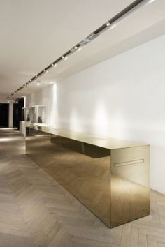 an empty room with white walls and wooden flooring is lit by recessed lighting