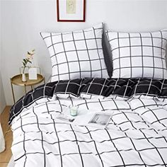 a bed with black and white checkered comforter set on top of wooden flooring