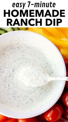 a white bowl filled with ranch dip surrounded by tomatoes and peppers