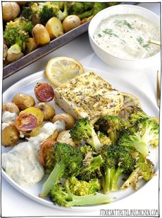 a white plate topped with broccoli and potatoes next to a bowl of dip