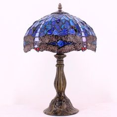 the lamp is made out of stained glass and has a blue shade on it's base