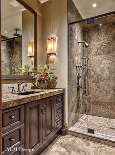 a bathroom with marble counter tops and wooden cabinets, along with a walk in shower