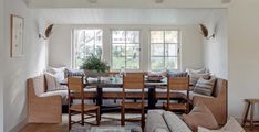 a living room filled with furniture next to a dining table and two couches in front of a window