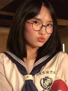 a girl wearing glasses and a sailor's outfit