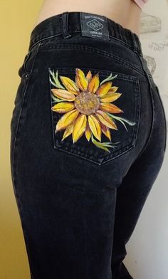 the back of a woman's jeans with an embroidered sunflower on it