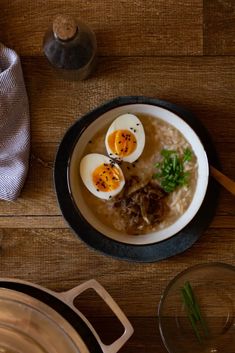 two boiled eggs sit on top of rice in a bowl with chopsticks next to it