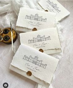 three pieces of white paper with writing on them next to a pair of gold scissors