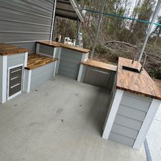 an outdoor kitchen made out of wood and metal with lots of counter space on the outside