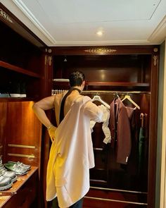 a man standing in front of a closet filled with clothes