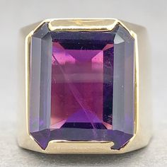 This vintage-inspired Estate 18K Y Gold Amethyst Cocktail Ring puts a modern spin on old-world charm. Featuring a mesmerizing 9.55ct emerald cut amethyst, set in a warm 18k yellow gold band of 16.18mm at the top and 9.57mm at the band, it's a stunning piece that can be sized to your finger! Start a new tradition in timeless luxury. One stamped & tested 18KT yellow gold lady's custom wax & cast gemstone fashion ring with a flat shank with rounded edges with a bright polish finish. The custom made Large Cocktail Ring, Amethyst Cocktail Ring, Amethyst Set, Timeless Luxury, Fashion Ring, Old World Charm, Gold Band, Cocktail Ring, Cocktail Rings