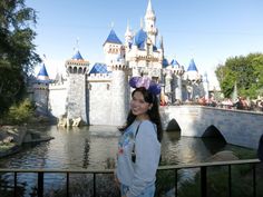 a woman standing in front of a castle