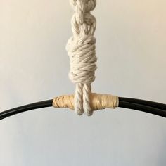 a white rope is hanging from a black pole