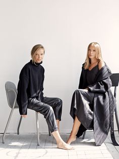 two women sitting on chairs in black clothing