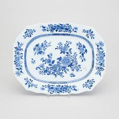 an ornate blue and white plate with flowers on it, in the shape of a rectangle