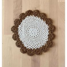 a brown and white doily sitting on top of a wooden floor