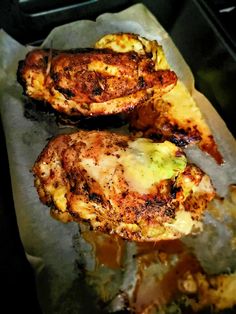 two pieces of chicken sitting on top of a piece of wax paper