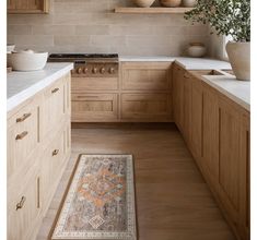 a kitchen with wooden cabinets and an area rug in front of the stove top oven