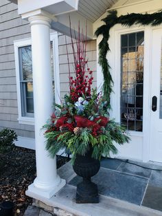 a large vase filled with flowers sitting on top of a porch