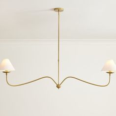 three light brass chandelier with white shades on the lampshades in a living room